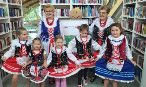 dzieci i starsze kobiety w strojach ludowych pozują do zdjęcia